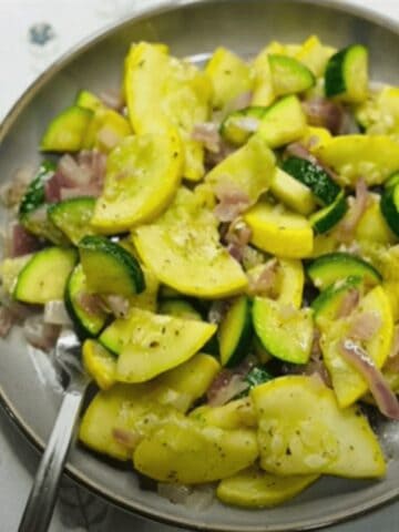 FBB_Side.Zucchini.Squash.Hero_.1200x1322.jpg. This is a photo of the seasoned zucchini and yellow squash on a plate with a fork, ready to enjoy.