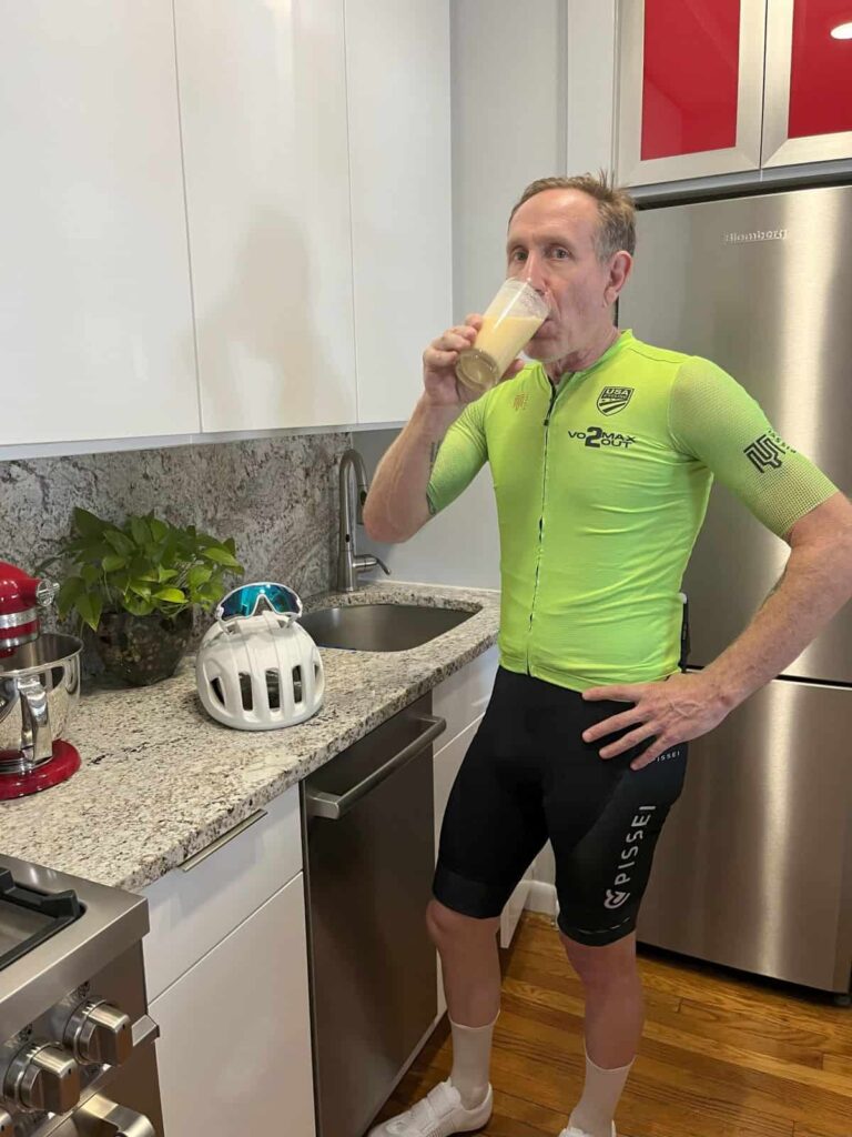 Will in the kitchen in his cycling apparel after a ride, enjoying a Mango Lassi (his version) for a recovery drink.
