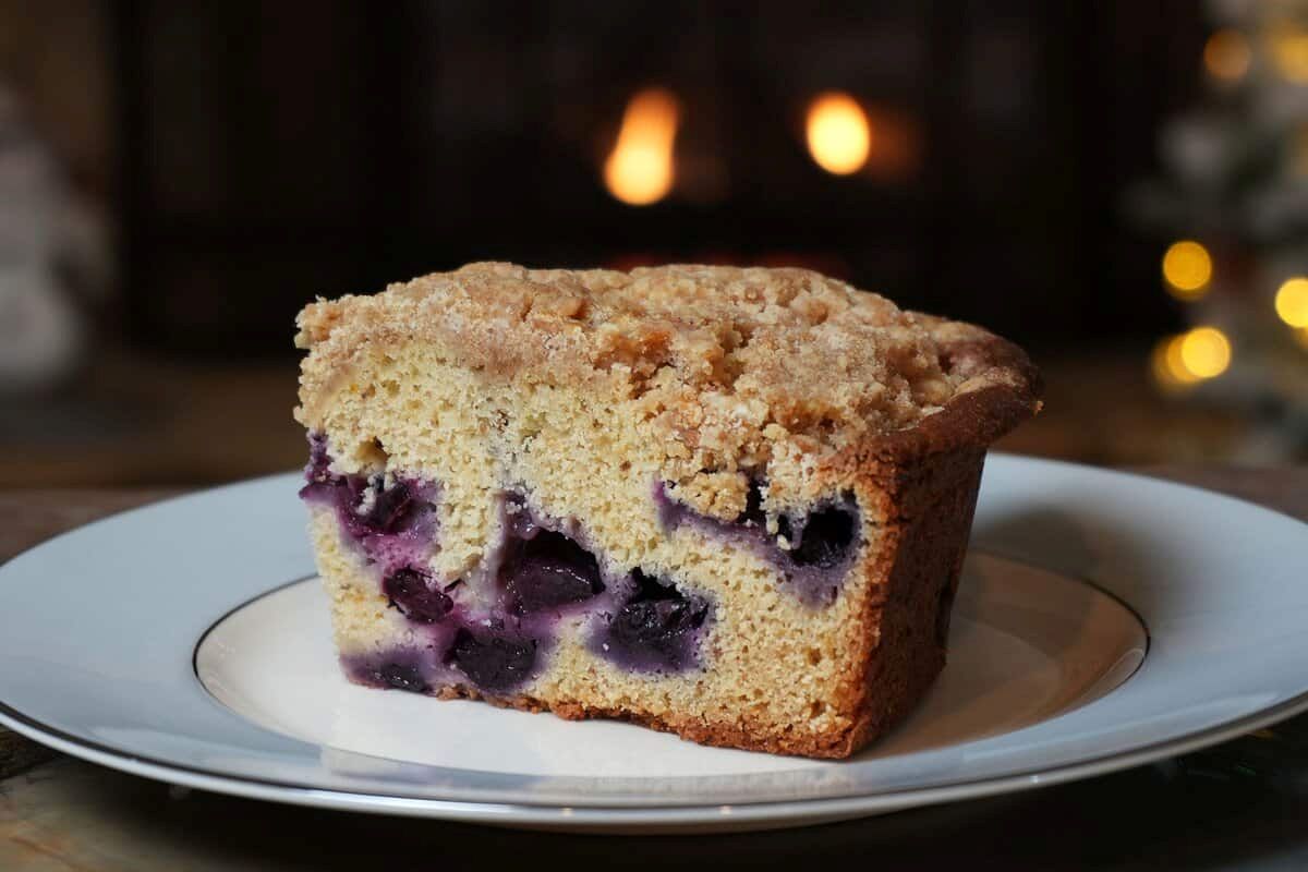 Moist blueberry crumb cake with streusel topping on a white and blue China plate