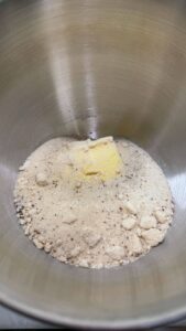 Butter nestled in a mixing bowl with flour, brown sugar, cardamom, and salt for the crumb topping.