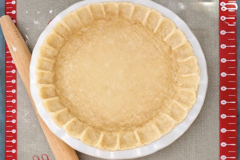Unbaked pie crust pressed into a pie dish with crimped edges.