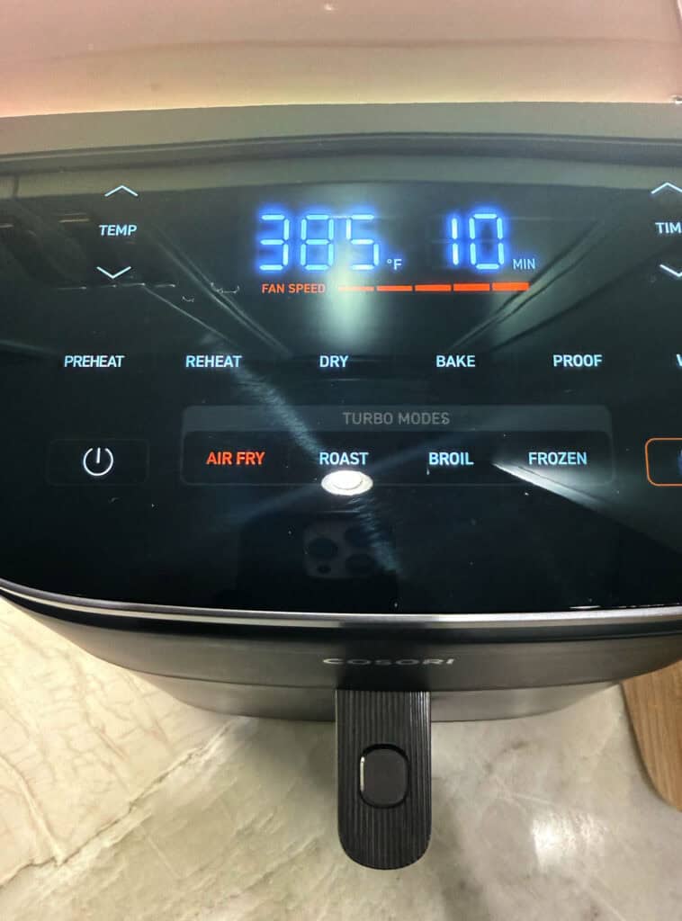 Close‑up of an air fryer control panel set to preheat at 400 degrees with the timer running.