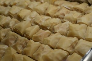Freshly baked baklava in a pan, golden and crisp, just out of the oven before adding orange blossom simple syrup.