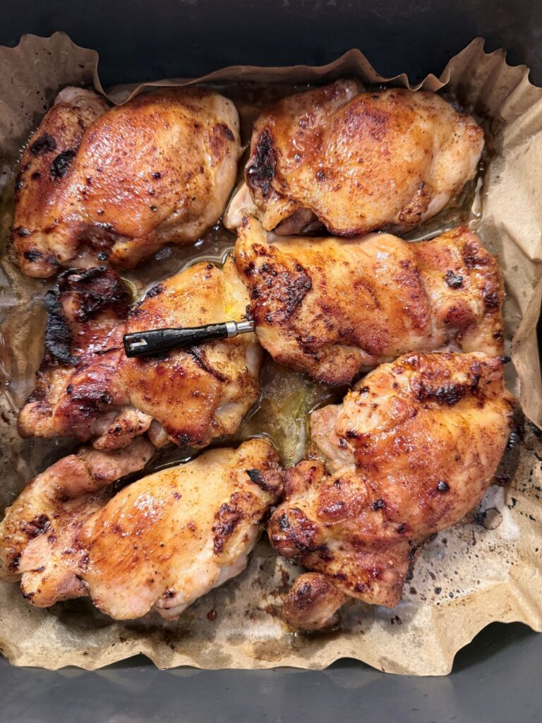 Glossy honey‑caramelized chicken thighs with golden, sticky edges fresh from the air fryer.