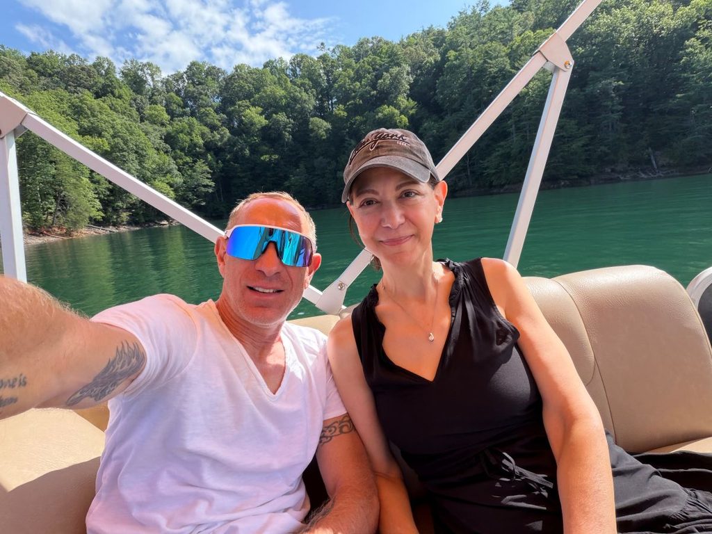 Samantha and Will relaxing on a pontoon boat at Lake Jocassee on a summer afternoon, enjoying the water, waterfalls, and mountain views.