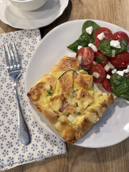 Hero plate with ham and Swiss croissant bake served alongside a fresh side salad.