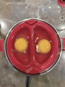 Poaching tray lightly sprayed with oil and filled with cracked eggs for Step 5